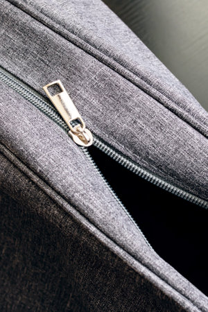 Open gray travel bag on a wooden background close up
