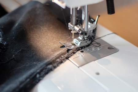Sewing machine needle and black cloth close up
