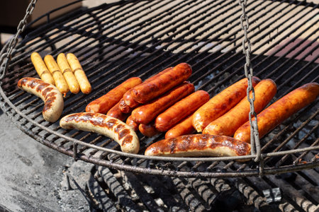 Grilled sausages on grill on the flame close upの写真素材