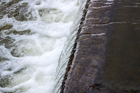 The flow of water in the city waterfall close upの写真素材