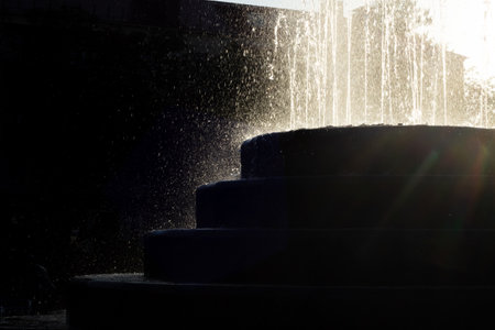 Splashes of the fountain at sunset close upの写真素材