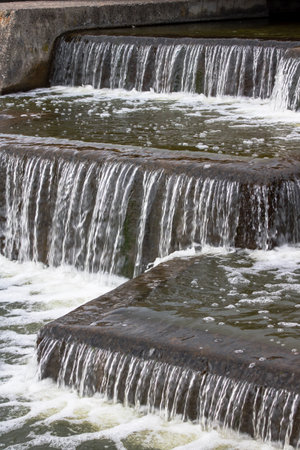 The flow of water in the city waterfall close upの写真素材