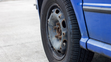 Wheel of a blue car close up on road