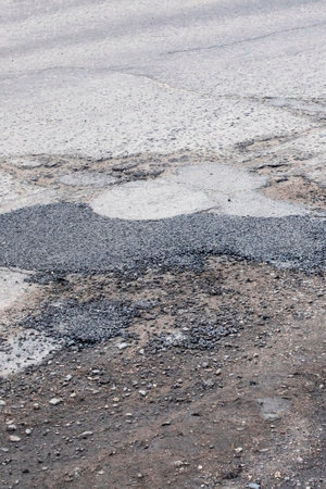 The holes in the road are filled with stonesの写真素材