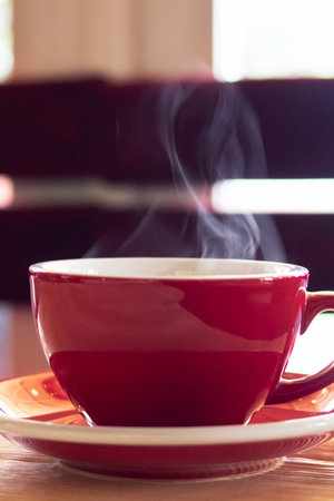 Red cup with steam on the table copy spaceの写真素材