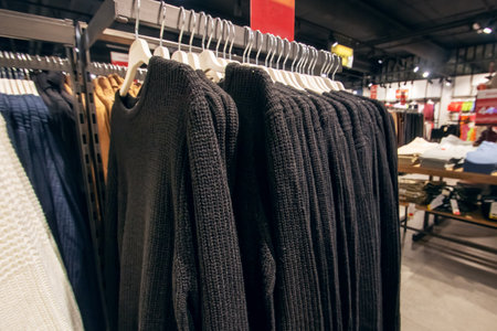Black sweaters on hangers in store close upの写真素材