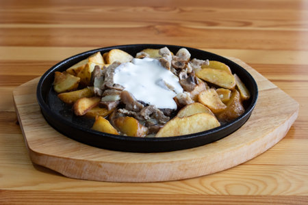 Potato dish with mushrooms on wooden tableの写真素材
