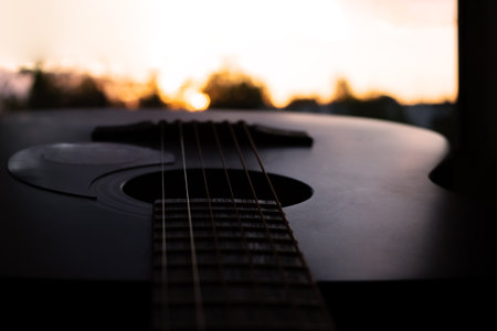 Guitar and strings on background of bright sunsetの写真素材