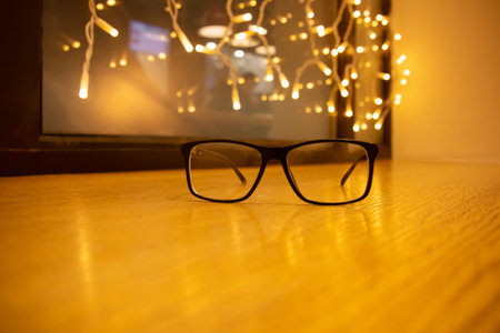 Glasses on the table on the background of a garlandの写真素材