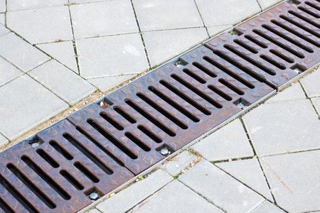 Long Rain drain on grass and pavement close upの写真素材