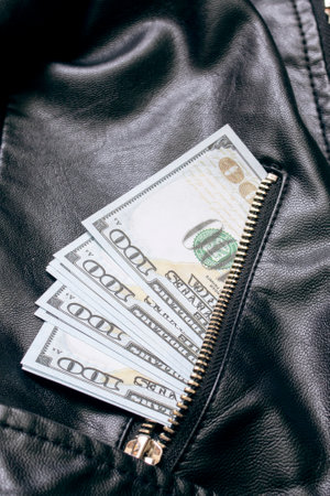 Dollars in the pocket of a leather jacket close upの写真素材