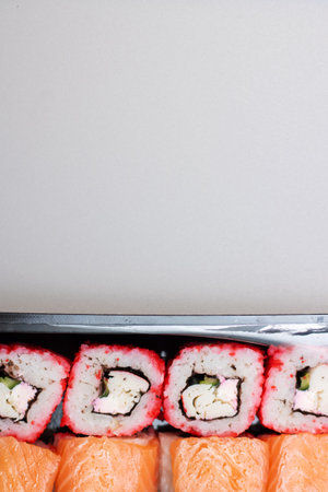 Bright beautiful rolls with fish close up on gray background