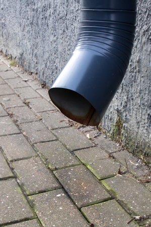 Downspout on the wall above the pavement close upの写真素材