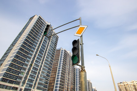 Green traffic light on the background of tall buildingsの写真素材