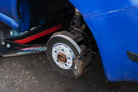 A wheel is removed from a blue car close upの写真素材