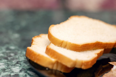 Food ingredients like slices of meat and bread served on a black plateの写真素材
