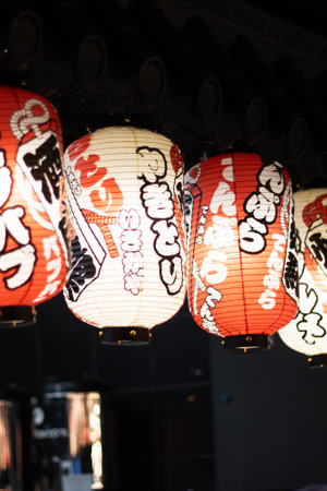 The restaurant is adorned with a row of colorful lanterns hanging from the ceiling, creating a vibrant atmosphere in the roomの写真素材