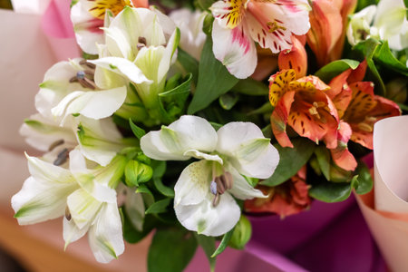 A beautiful bouquet of pink and yellow flowers, wrapped in paper. The vibrant colors of the petals make it perfect for flower arranging or as a natural ingredient in cookingの写真素材