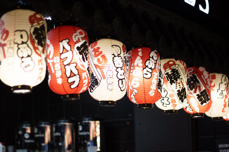 The restaurant is adorned with a row of colorful lanterns hanging from the ceiling, creating a vibrant atmosphere in the roomの写真素材