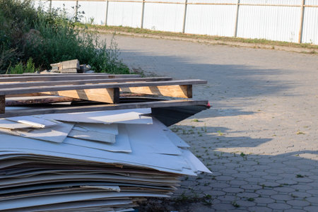 There is a stack of wooden pallets resting on the side of a roadの写真素材