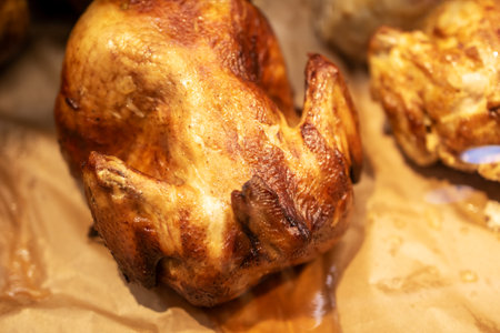 Close up of a perfectly roasted chicken on a piece of paperの写真素材