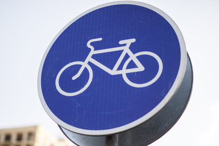 There is a blue sign displaying a white bicycle symbol on itの写真素材