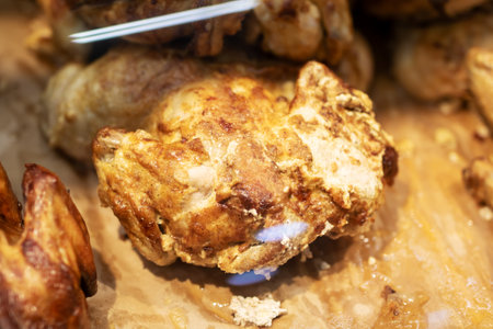 Here is a closeup view of a beautifully roasted chicken resting on a piece of white paper, showing its appetizing goldenbrown skin and juicy textureの写真素材