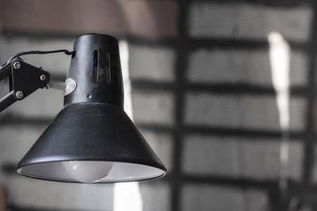 This image showcases a closeup view of a stylish black lamp featuring an elegant white shade mounted atop its baseの写真素材