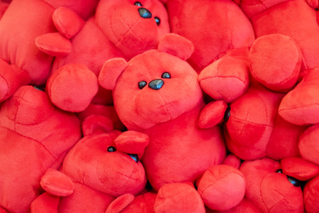 A sizable pile of adorable red teddy bears, each featuring bright blue eyes, arranged in a playful and charming mannerの写真素材