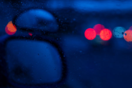 This image captures a detailed close up of a car's rear view mirror, showing the rain drops delicately resting on its reflective surfaceの写真素材