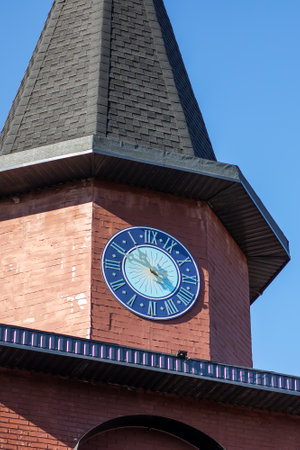 A breathtaking and stunning clock tower that features a vibrant blue clock face and a steeply peaked roof designの写真素材