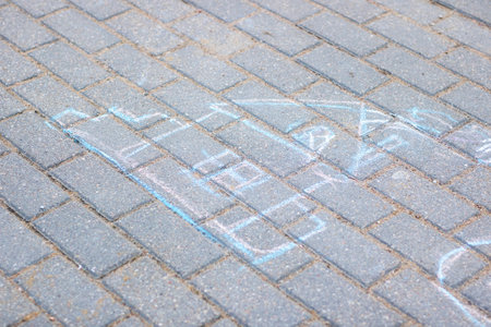 A detailed drawing is beautifully written in white chalk on a textured brick sidewalk, showcasing artistic creativityの写真素材