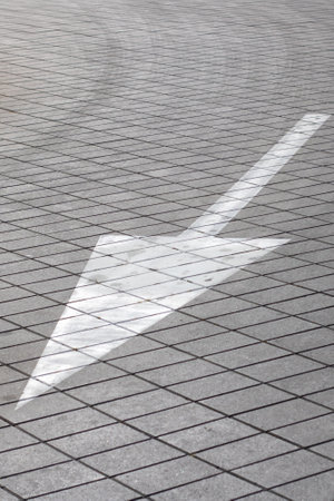 A large white arrow, designed to point towards the right direction, is prominently painted on the...