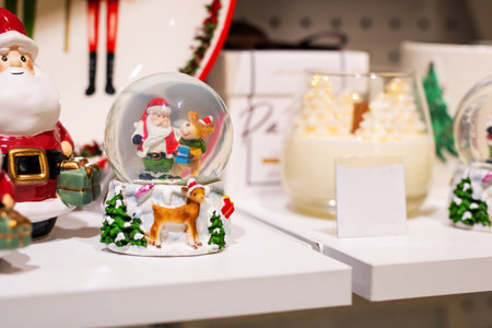 A beautifully crafted snow globe that contains a delightful scene featuring Santa Claus alongside some charming reindeer inside of itの写真素材