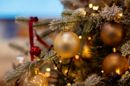A bright and shiny red disco ball is elegantly hanging from a beautifully decorated Christmas tree, sparkling with joy and festive cheerの写真素材