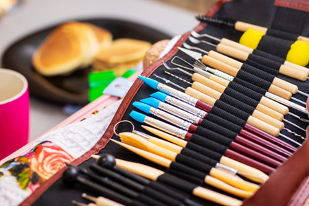 There is a collection of various brushes neatly arranged in a case resting on a table surface, ready for use or displayの写真素材