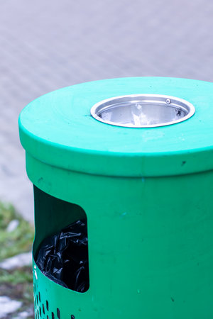 An overflowing ashtray packed tightly with used cigarettes and a tattered piece of crumpled paper...