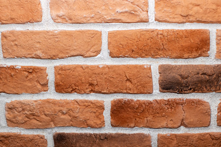 This is a detailed close up of a textured red brick wall, elegantly outlined by a contrasting white...