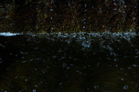 A detailed close up of a splash of water creating ripples in a serene body of water, capturing the...