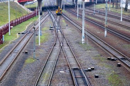 A bright yellow train is traveling down its designated train tracks, making its way toward the next...