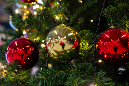 This is a beautifully detailed closeup view of a festive Christmas tree adorned with vibrant red and...