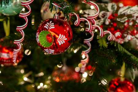A beautifully decorated Christmas tree adorned with vibrant red and green ornaments, along with...