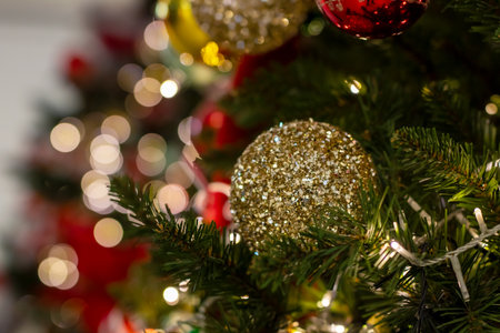 A beautifully decorated Christmas tree adorned with vibrant red and green ornaments, along with...