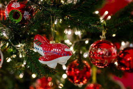 An eyecatching red airplane ornament is hanging from the Christmas treeの写真素材