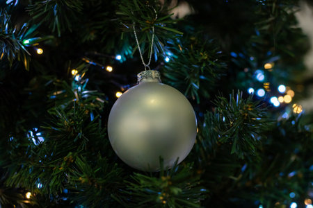 A decorated Christmas tree reflecting people in its shiny ornamentの写真素材