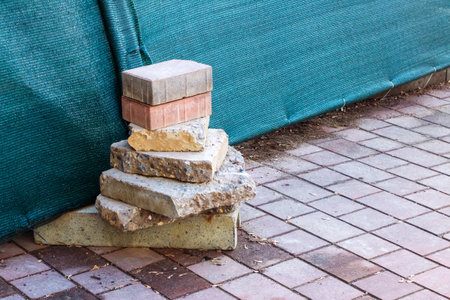A large pile of bricks is neatly stacked on top of one another on a solid brick sidewalk that stretches out before itの写真素材