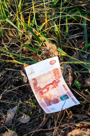 A Russian ruble bill is currently laying on the ground nearbyの写真素材
