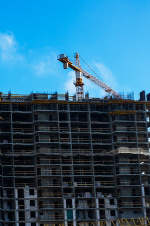 A dynamic construction site featuring multiple cranes and a significant highrise building that is...