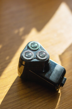 This image features a closeup view of a sleek shaver resting on a beautifully crafted wooden table, highlighting its elegant design and functionalityの写真素材