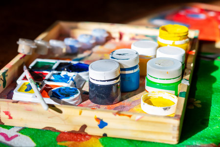 A beautifully crafted wooden box that is filled to the brim with various bottles of vibrant paint...